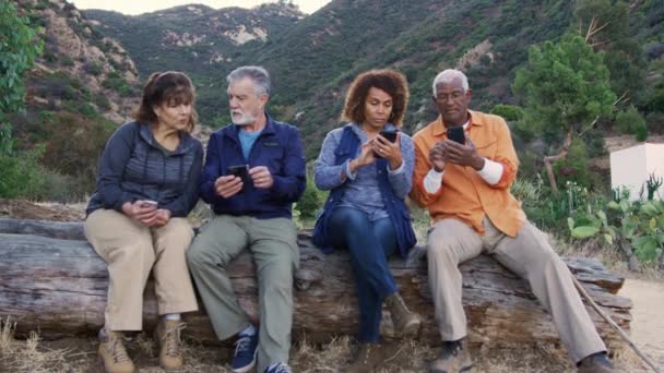 Gruppo Amici Anziani Escursione Campagna Seduti Sul Registro Controllo Telefoni — Video Stock