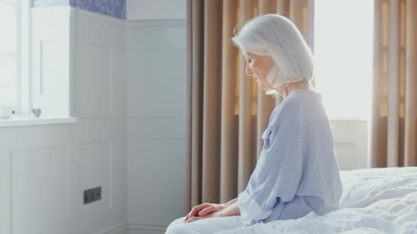 Несчастная Подавленная Пожилая Женщина Сидит Краю Кровати Дома Время Изоляции — стоковое видео