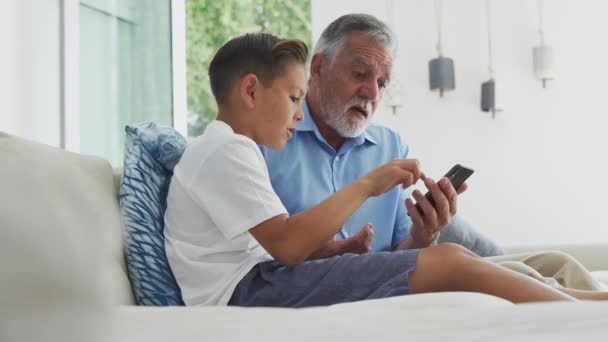 Hispánský Vnuk Ukazuje Dědečkovi Jak Používat Mobilní Telefon Doma Záběr — Stock video
