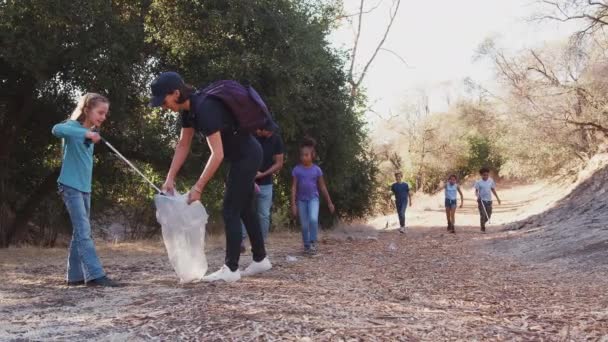 成人领队和一群孩子一起在室外活动营地捡垃圾 动作缓慢 — 图库视频影像