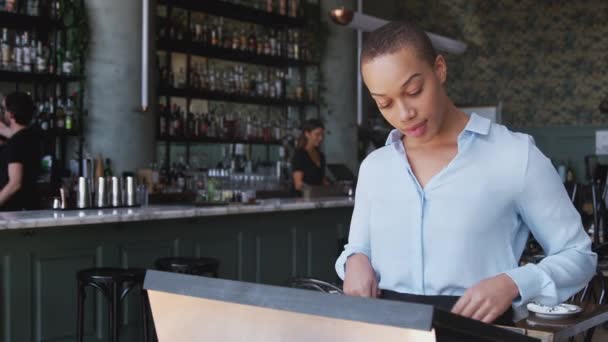 サービスの前に予約を確認してカウンターに立っているレストランバーの女性オーナー スローモーションで撮影 — ストック動画