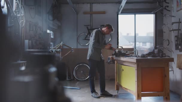 Άντρας Ιδιοκτήτης Επιχείρησης Στο Εργαστήριο Για Την Κατασκευή Ποδηλάτων Πριόνισμα — Αρχείο Βίντεο