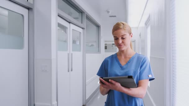 Kvinna Läkare Bär Skurar Med Digital Tablett Sjukhuskorridoren Skjuten Slow — Stockvideo