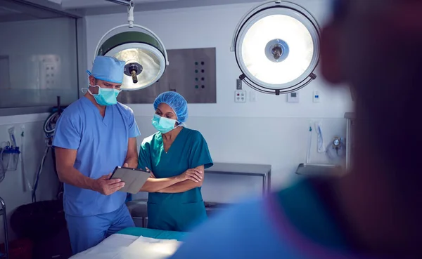 Άνδρας Και Γυναίκα Χειρουργοί Φορώντας Γρατζουνιές Κοιτάζοντας Ψηφιακή Ταμπλέτα Στο — Φωτογραφία Αρχείου