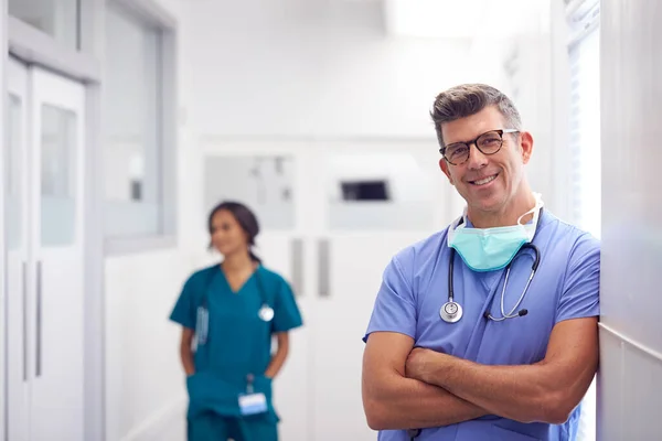 Porträt Von Reif Männlich Doktor Wearing Scrubs Standing Busy Hospital — Stockfoto