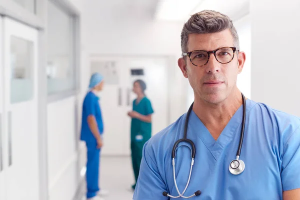 Portrét Dospělého Mužského Lékaře Nosící Podprsenky Stojící Rušné Nemocniční Chodbě — Stock fotografie