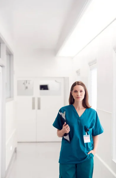 女医生头戴洗涤器 手持剪贴板站在医院走廊的画像 — 图库照片