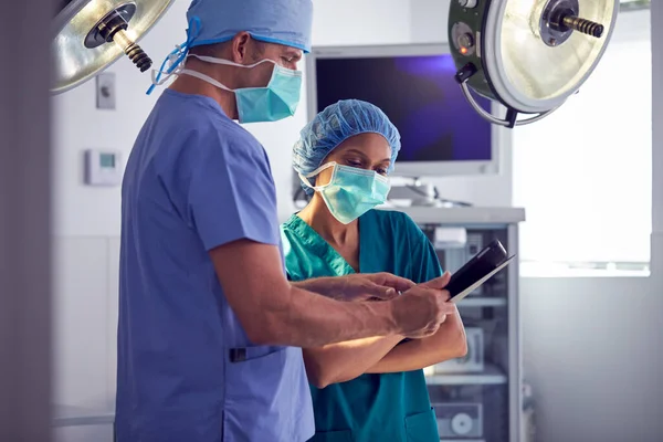 Άνδρας Και Γυναίκα Χειρουργοί Φορώντας Γρατζουνιές Κοιτάζοντας Ψηφιακή Ταμπλέτα Στο — Φωτογραφία Αρχείου