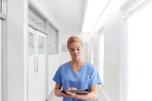 Médico Femenino Usando Exfoliantes Pasillo Del Hospital Usando Tableta Digital —  Fotos de Stock