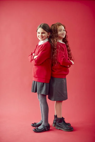 Twee Basisschoolleerlingen Dragen Uniform Tegen Achtergrond Van Red Studio — Stockfoto