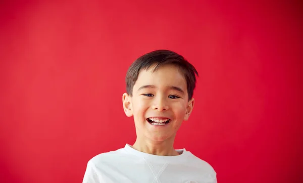 Portret Van Lachende Jonge Jongen Tegen Rode Studio Achtergrond Glimlachen — Stockfoto