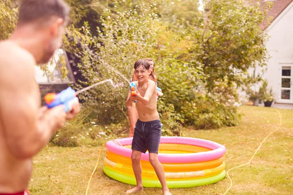 Vater Und Sohn Badeanzügen Kämpfen Sommergarten Mit Wasserpistolen — Stockfoto