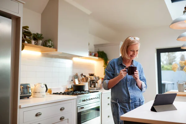 Mujer Madura Casa Cocina Bebiendo Café Mirando Tableta Digital — Foto de Stock