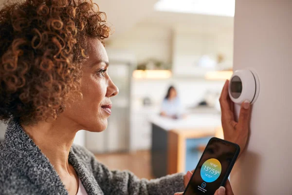 Mujer Madura Usando Aplicación Teléfono Para Controlar Termostato Calefacción Central — Foto de Stock