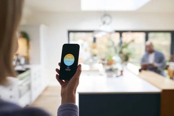 Moden Kvinde Bruger App Telefon Til Styre Digital Centralvarme Termostat - Stock-foto
