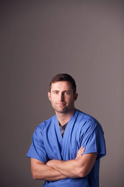 グレーを背景に立ち上がる男性看護師のスタジオポートレート — ストック写真