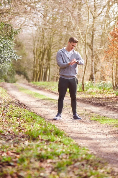 Man Running Countryside Exercício Verificando Smart Watch Fitness Activity App — Fotografia de Stock