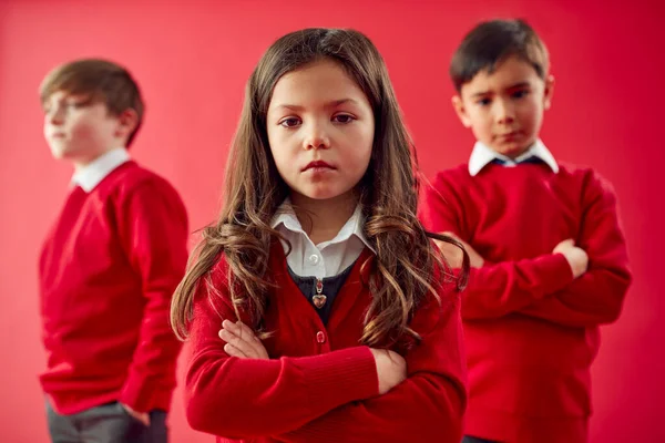 Groep Van Basisschoolleerlingen Dragen Uniforme Vouwarmen Tegen Achtergrond Van Red — Stockfoto