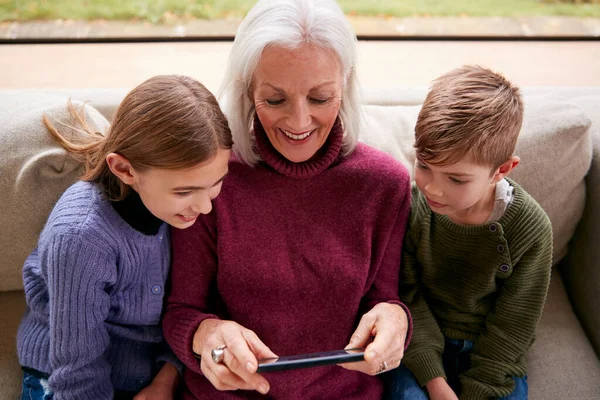 Barnbarn Soffan Hemma Visar Mormor Hur Man Använder Mobiltelefon — Stockfoto