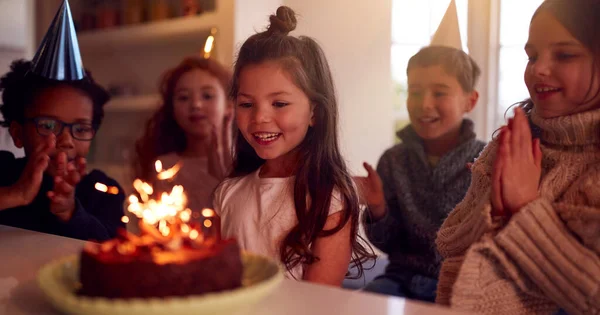 スパークラーで飾られたケーキを与えられて自宅で友人のグループと誕生日を祝う女の子 — ストック写真