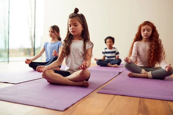 Gruppe Von Kindern Sitzt Auf Gymnastikmatten Und Meditiert Yoga Studio — Stockfoto