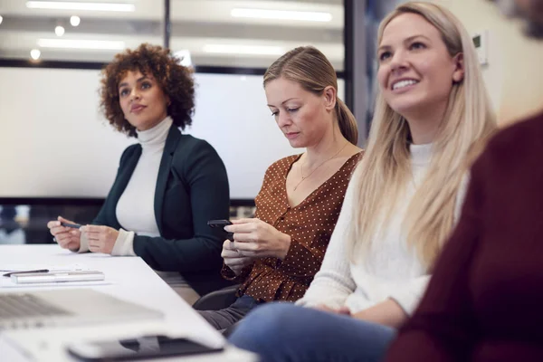 Mujer Negocios Mirando Teléfono Móvil Durante Presentación Por Colega Oficina — Foto de Stock