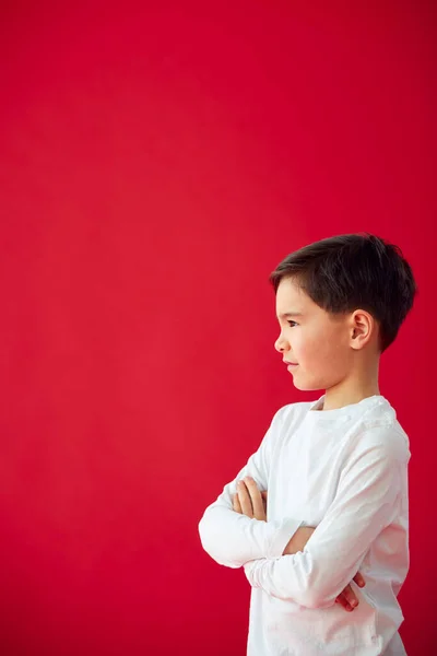 Porträt Eines Kleinen Jungen Mit Verschränkten Armen Vor Rotem Studiohintergrund — Stockfoto