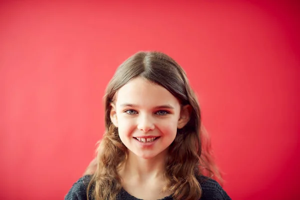 Portret Van Meisje Tegen Rode Studio Achtergrond Glimlachen Camera — Stockfoto