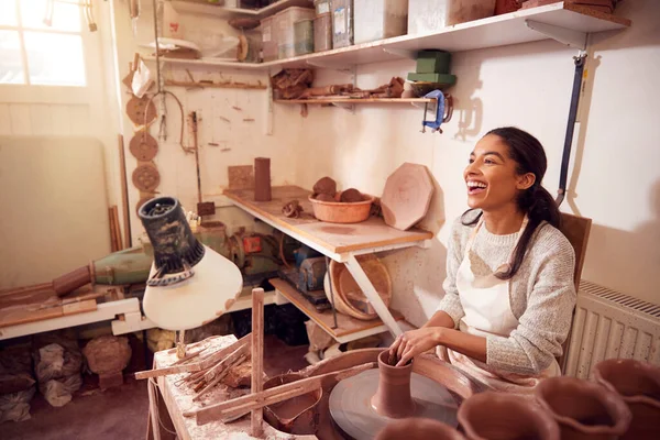 陶瓷工作室中女性波特为陶瓷轮上的小孔塑造粘土 — 图库照片