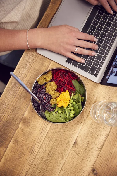 Zblízka Podnikatelka Pracuje Notebooku Zatímco Jíst Vegan Oběd Dřevěného Stolu — Stock fotografie