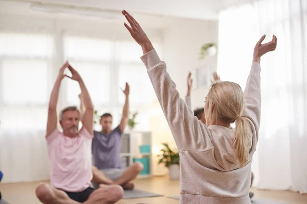 Grupo Con Profesor Sentado Colchonetas Ejercicio Estirándose Clase Yoga Dentro —  Fotos de Stock