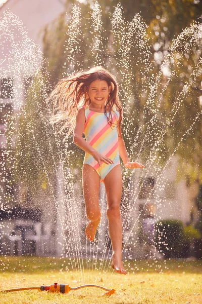 Menina Vestindo Trajes Natação Divertindo Jardim Verão Jogando Água Aspersor — Fotografia de Stock