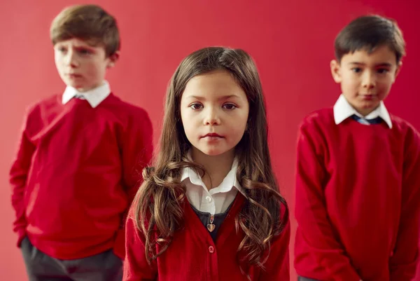 Group Pupils Wearing Uniform Red Studio Background — 스톡 사진