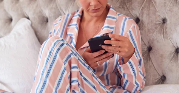 Mujer Pijama Sentada Cama Con Teléfono Móvil Chequeando Mensajes —  Fotos de Stock