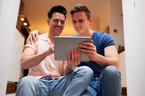 在家中放松时 使用数码记事板爱同性男性伴侣 — 图库照片