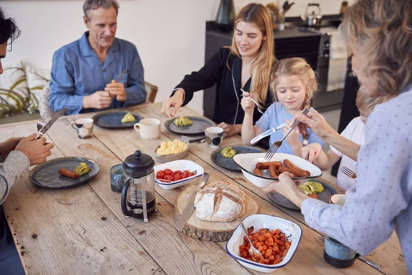 Multi Generation Family Sitting Table Home Pyjamas Enjoying Brunch Together — Stock Photo, Image
