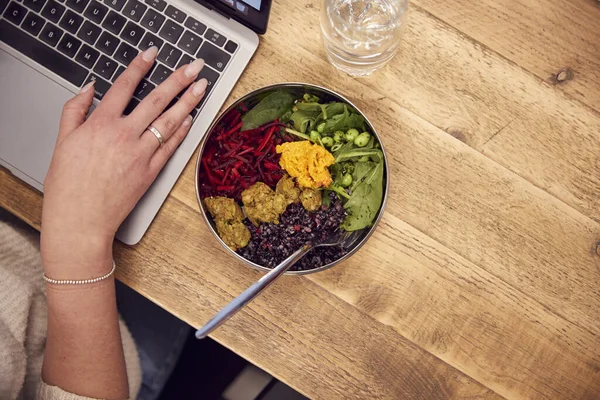 Zblízka Podnikatelka Pracuje Notebooku Zatímco Jíst Vegan Oběd Dřevěného Stolu — Stock fotografie