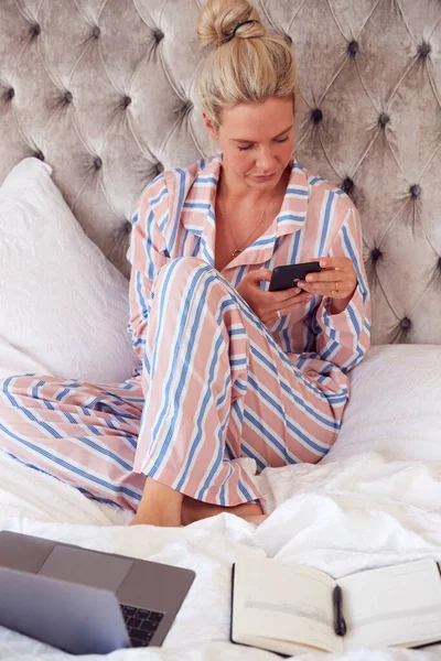 Mujer Negocios Pijama Sentada Cama Con Computadora Portátil Teléfono Móvil — Foto de Stock