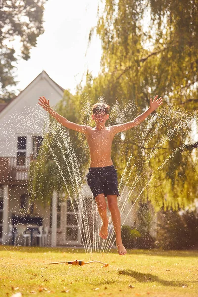 Menino Vestindo Trajes Natação Divertindo Jardim Verão Brincando Água Aspersor — Fotografia de Stock