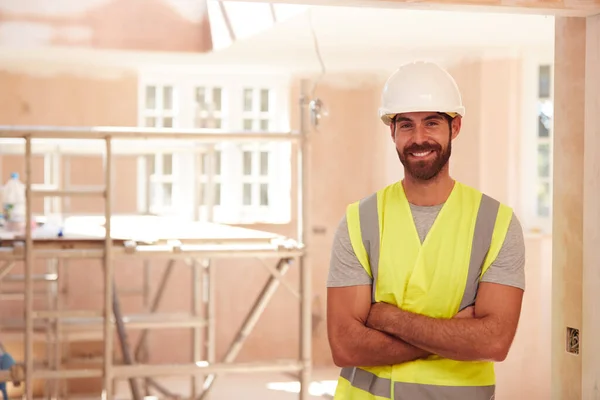 新建筑中穿着硬帽的男性建筑工人的画像 — 图库照片