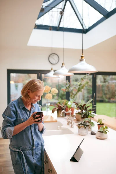 Volwassen Vrouw Thuis Keuken Drinken Koffie Kijken Naar Digitale Tablet — Stockfoto