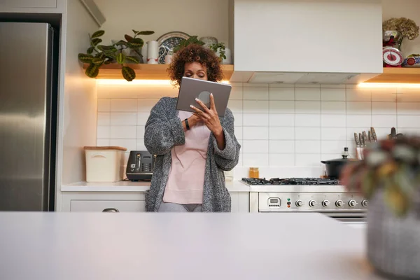 Mutfakta Pijamalı Afro Amerikan Kadın Dijital Tablete Bakıyor — Stok fotoğraf