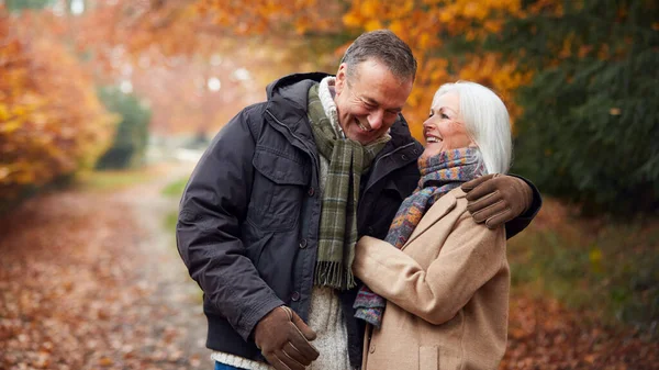 Liebendes Senioren Paar Umarmt Sich Beim Spaziergang Auf Herbstholzpfad Durch — Stockfoto