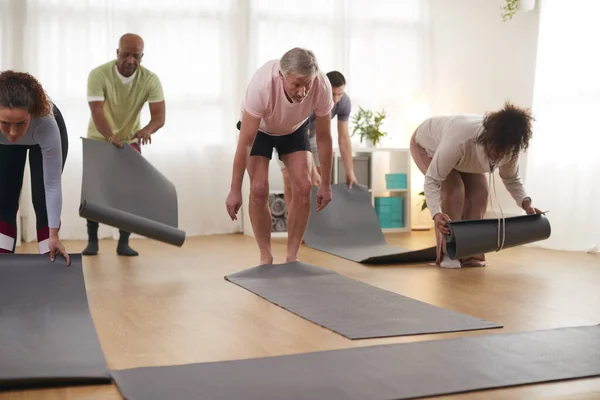 Grupa Osób Rozwijania Maty Treningowe Przed Rozpoczęciem Fitness Lub Jogi — Zdjęcie stockowe