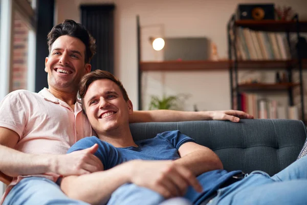 Loving Same Sex Male Couple Lying Sofa Home Watching Relaxing — стоковое фото