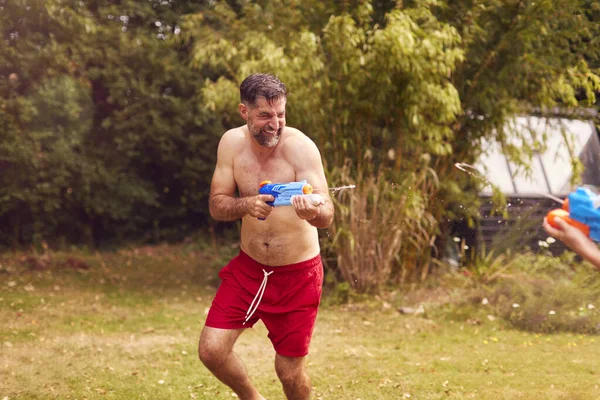 Vader Zoon Dragen Zwemkostuums Die Met Waterpistolen Vechten Zomertuin — Stockfoto