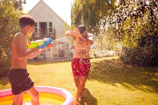 Perhe Yllään Uimahousut Ottaa Vesi Taistella Vesi Pistoolit Summer Garden — kuvapankkivalokuva