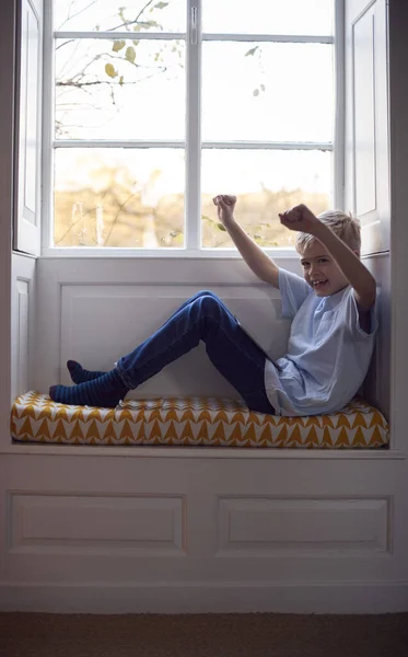 Portrét Vzrušeného Mladého Chlapce Sedícího Sedadle Okna Doma Hrajícího Digitální — Stock fotografie