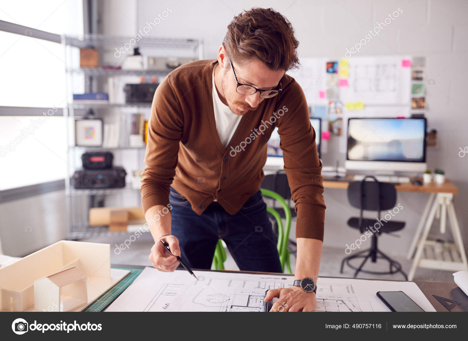 Male Architect Standing Desk Office Amending Building Plans Stock Photo