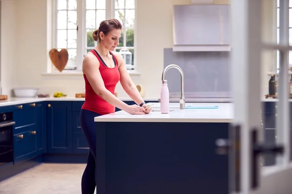 Mulher Madura Vestindo Roupas Fitness Verificando Mensagens Casa Cozinha Após — Fotografia de Stock